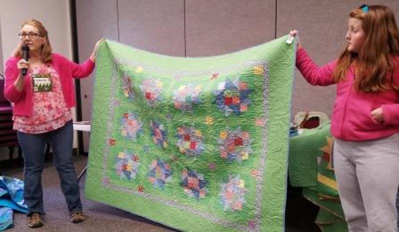 Anita is showing a set of quilts made for grandchildren that also demonstrates the effect of color choices